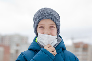 The danger of coronavirus. A boy on a walk walks in a medical mask on his face