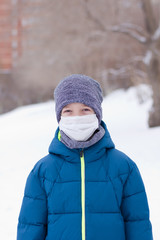 The danger of coronavirus. A boy on a walk walks in a medical mask on his face