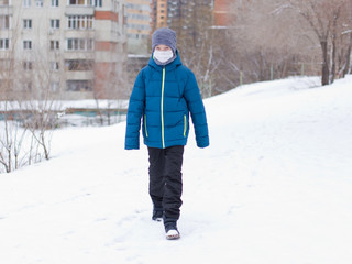 The danger of coronavirus. A boy on a walk walks in a medical mask on his face