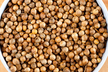 Coriander grains shot large on a wooden background. Background for spices and cuisine.