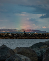 man standing in rainbow