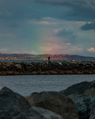man standing in rainbow