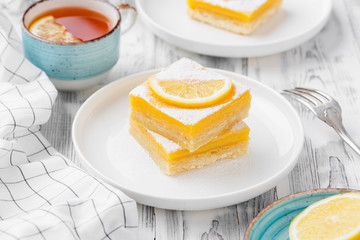 Lemon bar dessert with powdered sugar and lemon slices