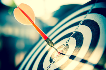 Bullseye(bull's-eye) or dart board has dart arrow hitting the center of a shooting target for...