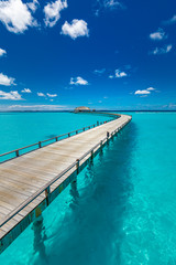 Fototapeta na wymiar Perfect landscape of Maldives beach. Tropical panorama, luxury water villa resort with wooden pier or jetty. Luxury travel destination background for summer holiday and vacation concept.