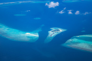 The drone photo with a wooden water villas seen from above and an amazing blue lagoon crystal clear water close to tropical lagoon. Amazing summer travel and vacation background. Dreamy beach scenery