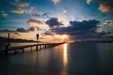 Fototapeta na wymiar Wooden pier on the seashore during sunrise