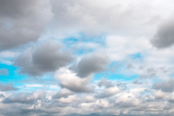 Blue sky with white soft clouds. Pleasant warm summer weather.