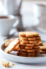 Fototapeta na wymiar Freshly baked homamade cookies for breakfast with cups of coffee at the background