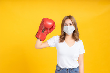 Young asian woman with medical mask protection coronavirus COVID-19 fighting wearing boxing gloves...