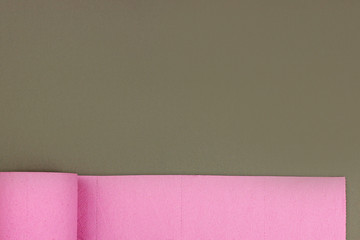 Roll of pink toilet paper on dark grey background. top view. Space for text