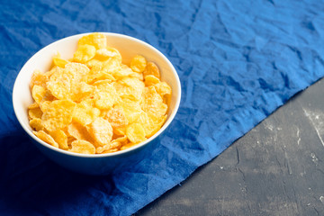 Tasty crispy corn flakes in bowl on the rustic background. Selective focus. Shallow depth of field.