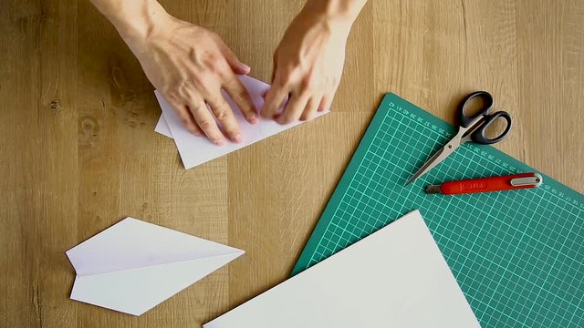 man folds of paper origami air plane