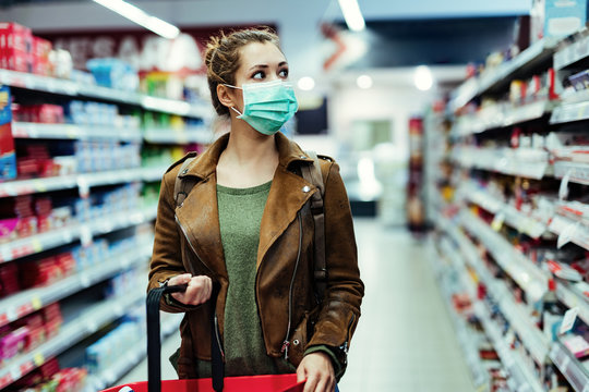 Woman wearing face mask while shopping in supermarket during virus pandemic.