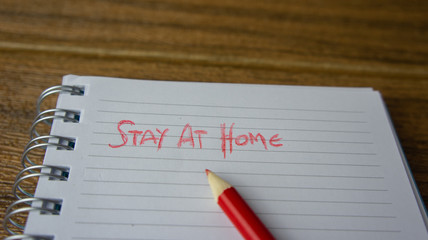 A paper with text Stay at Home. Concept work from home during covid 19 crisis.