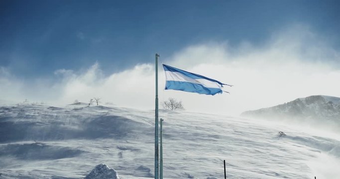 Slow motion of Argentinian flag in a windy and snowy day of winter. 120 frames per second.