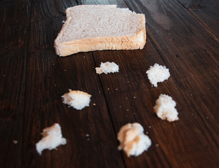 White bread and crumbs on a wooden background. Close up.