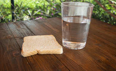 Bread and water on a wooden table