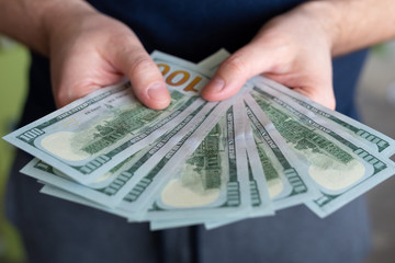 Dollars in man's hands. Profits, savings. Success, motivation, financial flows, wealth. Stack of dollars. 100 us dollars