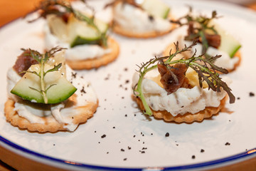 Appetizing little canapes on a plate. Close-up.