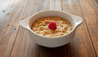 Fresh porridge on the wooden background