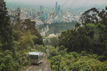 Panorama of Bogota funicular to Montserrat cathedral in the Colombian capital on a hazy day. Train just moving past the other car going uphill.