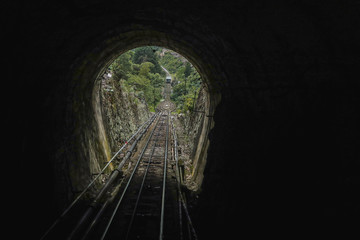 View in a tunnel at Bogota funicular to Montserrat cathedral in the Colombian capital on a hazy day. Train just exiting the tunnel going downhill.