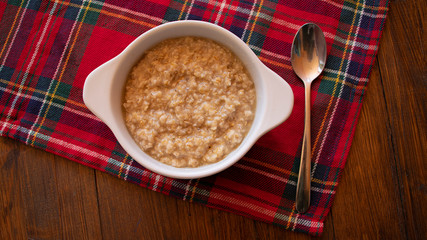 Fresh porridge with spoon on the wooden table