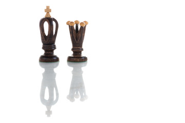 A view of king and queen black chess pieces. Wooden chess pieces against white color background