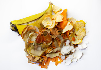 Waste from the food industries the carrots, banana, potatoes, orange, onion, egg shell on a white background. Flat lay. Top view. Waste for recycling.