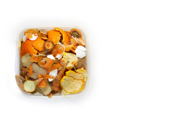 Food waste carrots, bananas, potatoes, oranges, onions, eggshells in a container on a white background. Top view. Flat lay. Copy space. Waste for recycling.