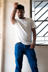 Portrait of a handsome brunette Indian bengali smart man in shirt and trousers standing in a stair...