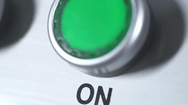 Green button power on. Finger pushing button. Start engine electrical equipment in industrial factory. Panel with green plastic round pressbutton. Beginning of work. Switch on. Turn on the electricity