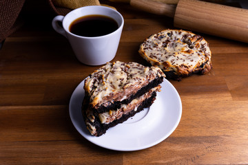 Delicious cookie cakes with chocolate and cheesecake with a cup of coffee on a wooden board with copy space