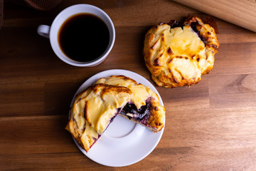 Delicious cheesecake cookie cakes with blueberries and a cup of coffee on a wooden board with copy space