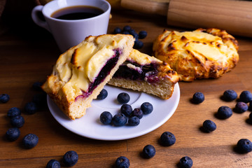 Delicious cheesecake cookie cakes with blueberries and a cup of coffee on a wooden board with copy space