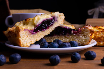 Delicious cheesecake cookie cakes with blueberries and a cup of coffee on a wooden board with copy space