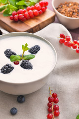 Bowl with tasty yogurt and berries on table