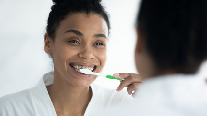 Personal oral hygiene and dental care concept. African ethnicity beautiful 30s woman woke up in...