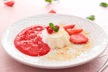 Plate with tasty panna cotta on color background
