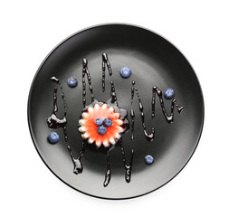 Plate with tasty panna cotta on white background
