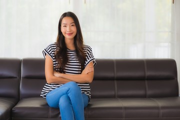 Portrait beautiful young asian woman happy smile relax on sofa in living room
