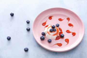 Plate with tasty panna cotta on color background