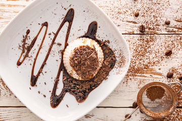 Plate with tasty panna cotta on table