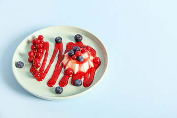 Plate with tasty panna cotta on color background