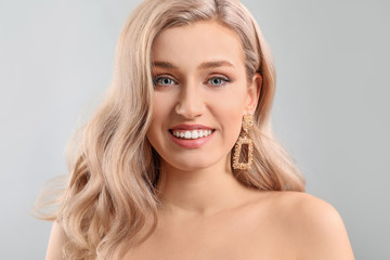 Young blonde with beautiful hair on light background