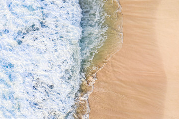 View from above, stunning aerial view of waves crashing onto a beautiful beach during a sunny day. Nyang Nyang Beach (Pantai Nyang Nyang), South Bali, Indonesia...