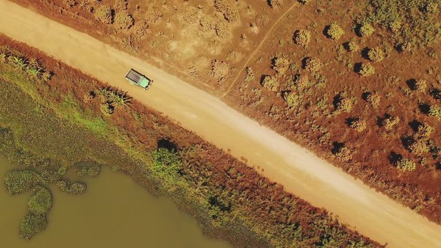 Un camion circule sur une route de terre et de sable orange vue du dessus en faisant beaucoup de poussi&egrave;re vers Phnom Penh, au Cambodge, en Asie.