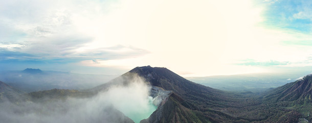Panoramic view of the Ijen volcano with the turquoise-coloured acidic crater lake during sunrise. The Ijen volcano complex is a group of composite volcanoes located in East Java, Indonesia.