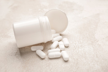 Jar with pills on light background
